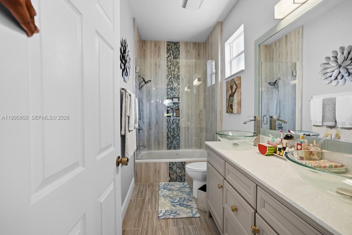 337 Southwest Maclay Way Port St. Lucie, FL 34986 - Photo 16 of 44 a bathroom with a double vanity sink a mirror and shower