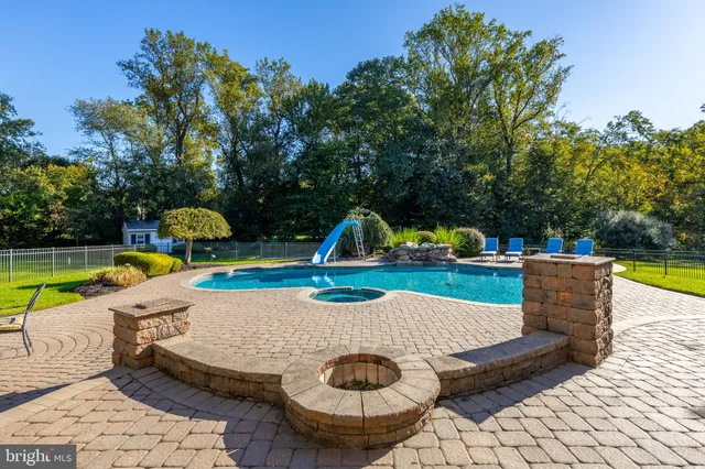 a view of a yard in front of a house with plants and large tree