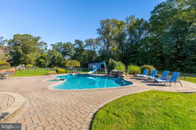 a kitchen with stainless steel appliances kitchen island granite countertop a table chairs in it and wooden floors