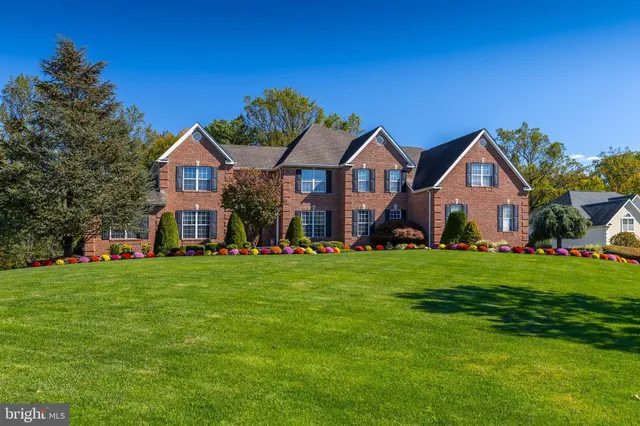 a front view of a house with a yard and trees