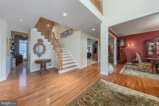 a dining room with wooden floor a chandelier a wooden table and chairs