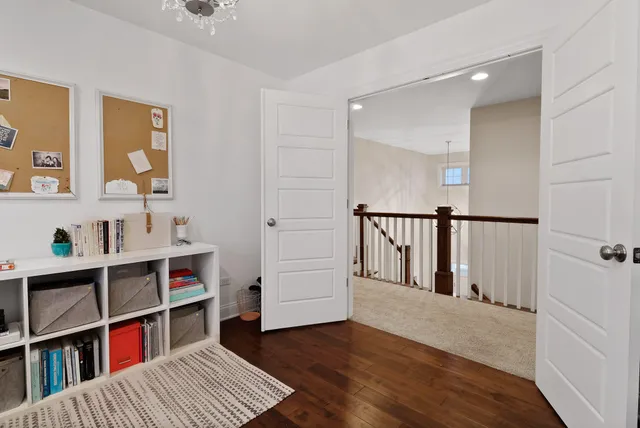 a view of hallway with wooden floor and furniture