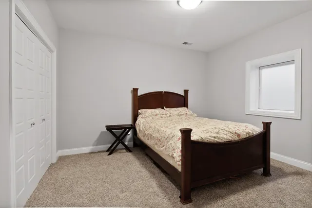 a bed sitting in a bedroom next to a window