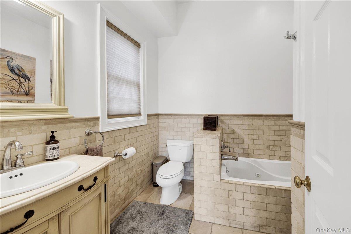 2 Harbor Lane, Unit 102 New Rochelle, NY 10805 - Photo 15 of 30 This bathroom features a vanity with a sink and faucet, a toilet, and a bathtub