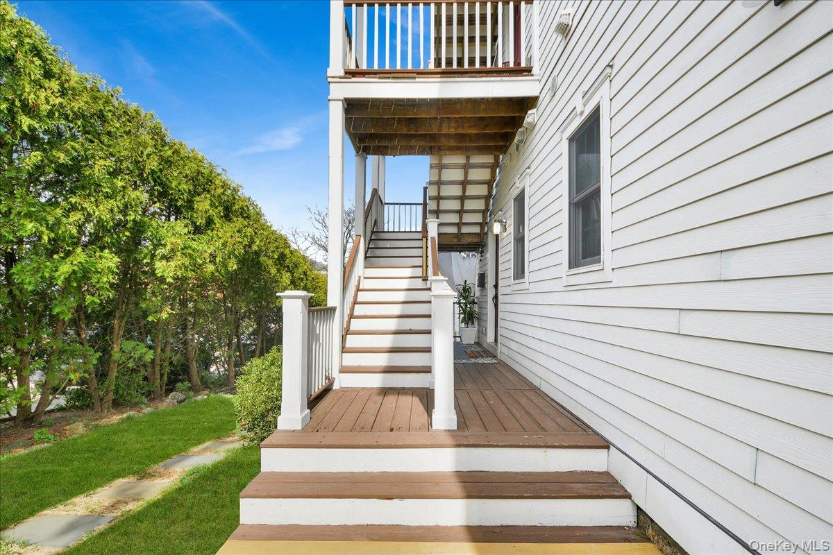 2 Harbor Lane, Unit 102 New Rochelle, NY 10805 - Photo 21 of 30 The property features white horizontal siding and a multi-level deck with wooden steps and white railings