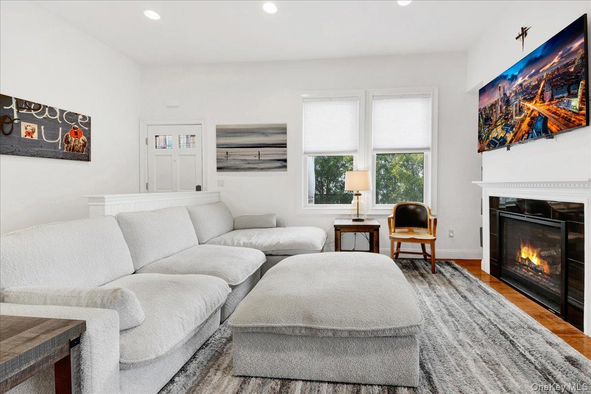 2 Harbor Lane, Unit 102 New Rochelle, NY 10805 - Photo 6 of 30 The living area features hardwood floors, a fireplace with a white mantel, and windows providing natural light
