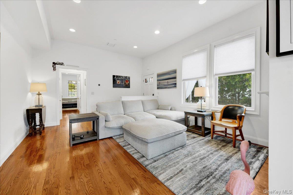 2 Harbor Lane, Unit 102 New Rochelle, NY 10805 - Photo 7 of 30 Living room featuring polished hardwood flooring, white walls, and windows providing natural light