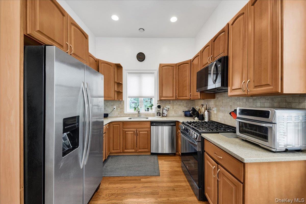 2 Harbor Lane, Unit 102 New Rochelle, NY 10805 - Photo 9 of 30 The kitchen features light wood cabinetry, stainless steel appliances, and hardwood floors.