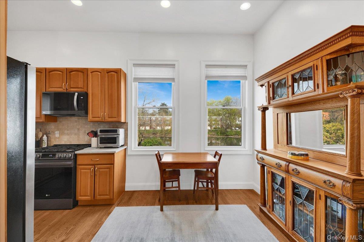 2 Harbor Lane, Unit 102 New Rochelle, NY 10805 - Photo 10 of 30 The kitchen features wood cabinetry, a stainless steel range, and a tile backsplash