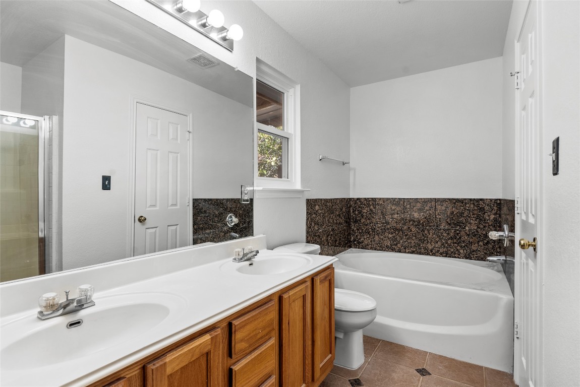 212 Valley Run Trail Elgin, TX 78621 - Photo 13 of 31 a bathroom with a tub a sink and a large mirror