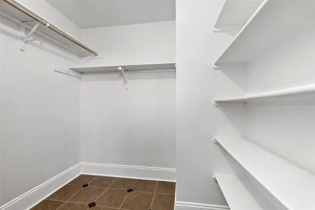 a view of walk in closet with empty racks