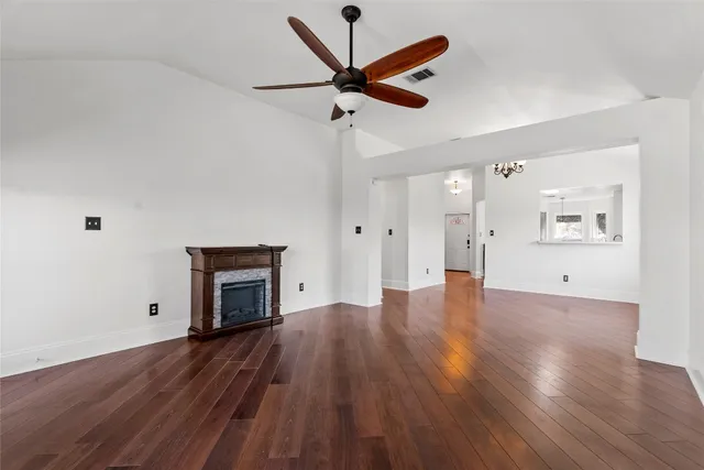 a view of empty room with wooden floor and ceiling fan