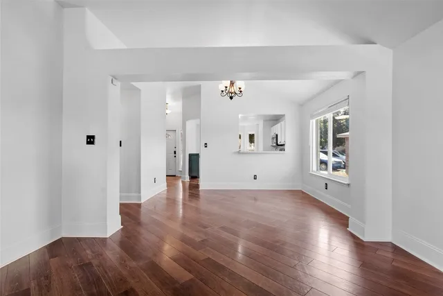 a view of a big room with wooden floor and a kitchen