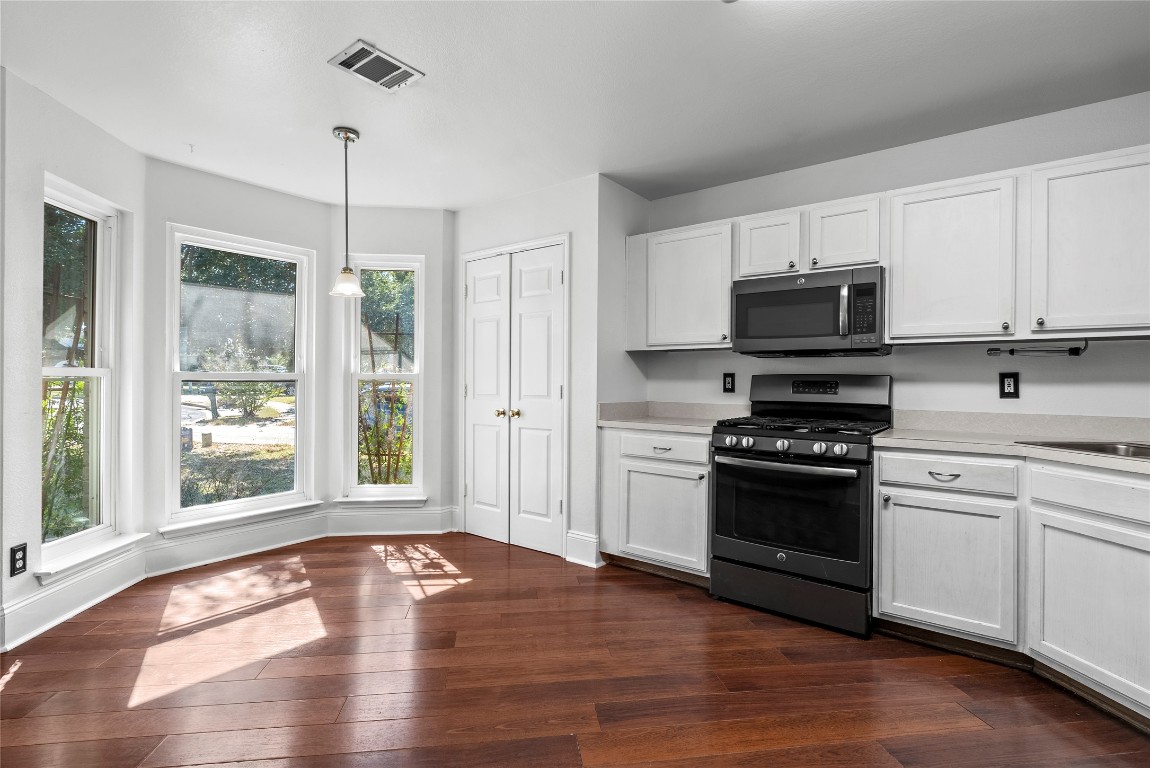 212 Valley Run Trail Elgin, TX 78621 - Photo 6 of 31 a kitchen with granite countertop a stove a sink and a wooden floors