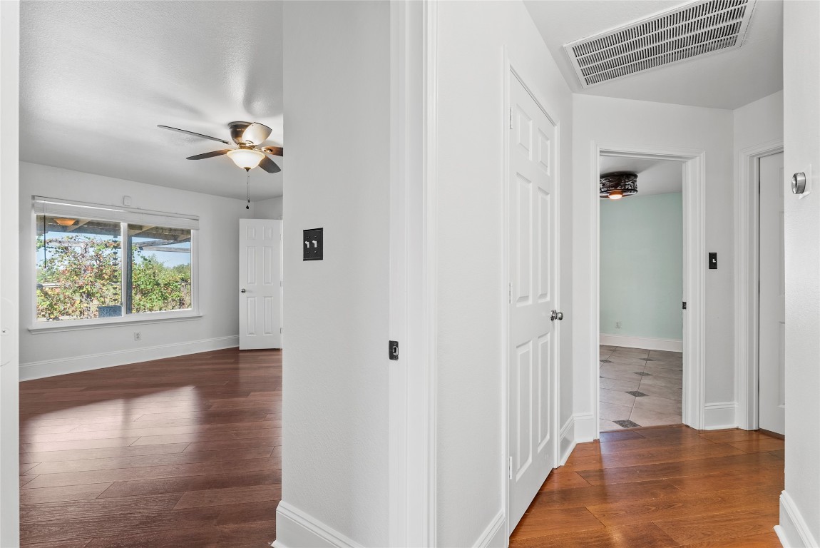 212 Valley Run Trail Elgin, TX 78621 - Photo 9 of 31 a view of a hallway with wooden floor and a bathroom
