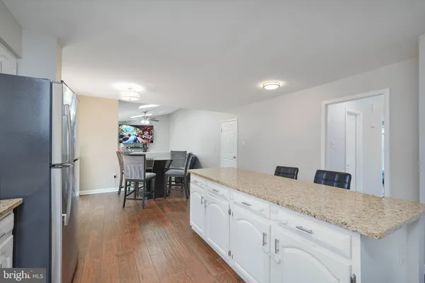 a kitchen with granite countertop kitchen island white cabinets and stainless steel appliances