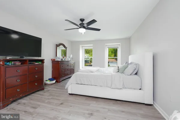 a bedroom with a large bed and flat tv screen on dresser
