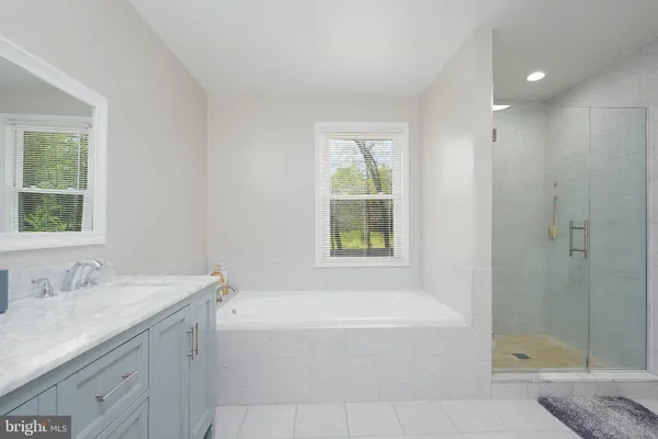 a spacious bathroom with sink shower and bathtub