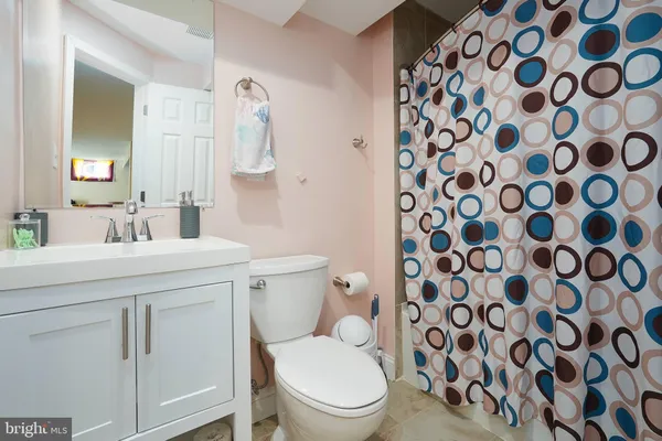 a bathroom with a toilet and a sink a mirror