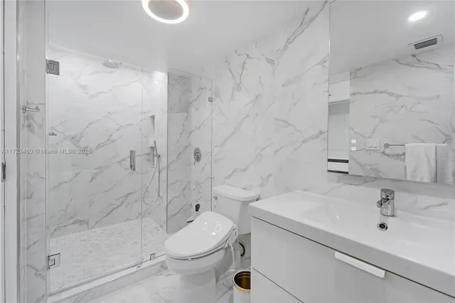 a bathroom with a sink a toilet and shower