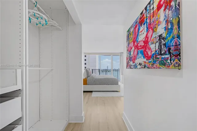 a hallway with painting on the wall and a potted plant