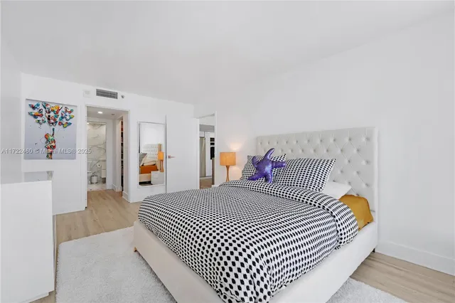 a bedroom with a large bed and a chandelier