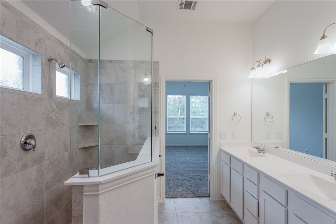 312 Prato Place Georgetown, TX 78628 - Photo 18 of 33 a bathroom with a double vanity sink a toilet and shower