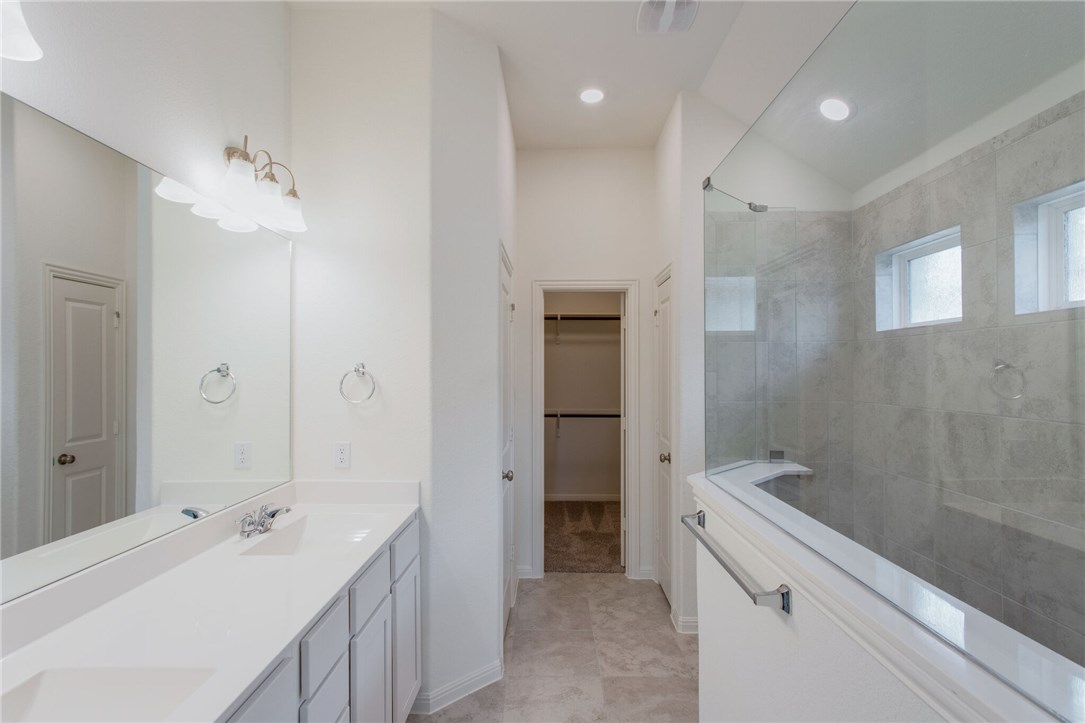 312 Prato Place Georgetown, TX 78628 - Photo 19 of 33 a bathroom with a double vanity sink a toilet and shower