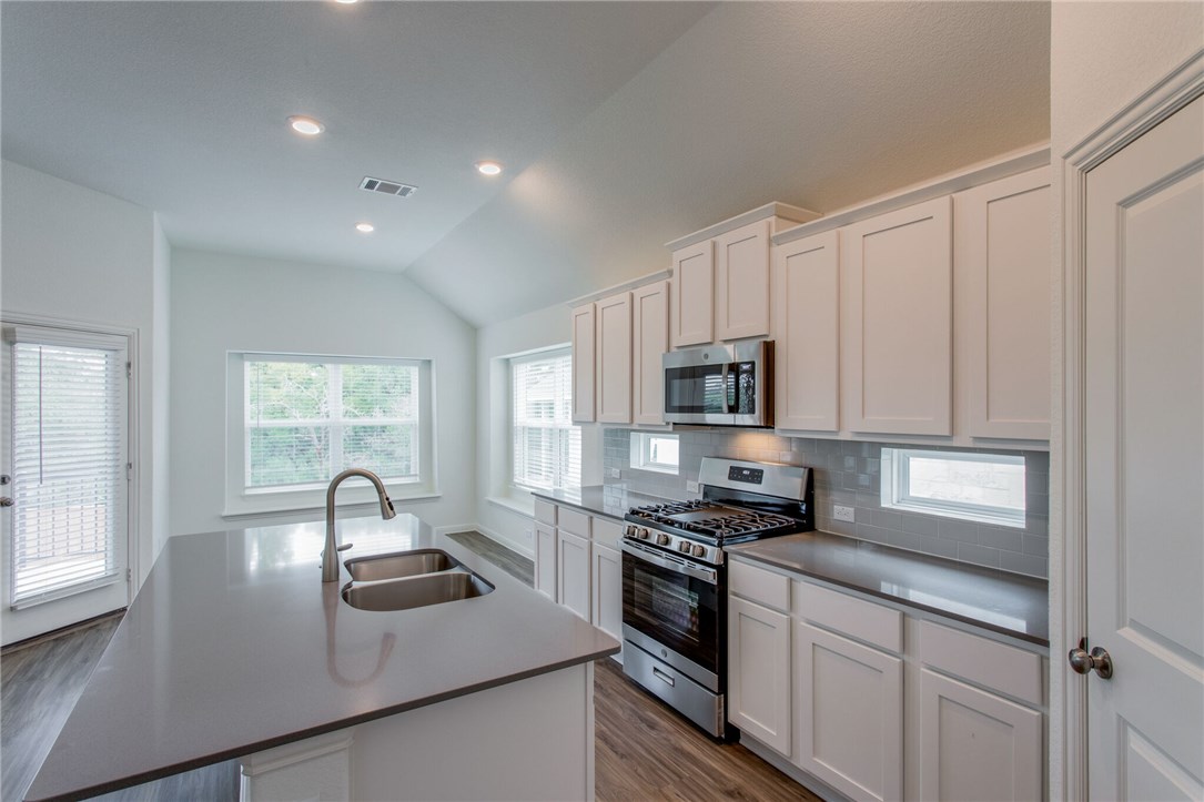 312 Prato Place Georgetown, TX 78628 - Photo 26 of 33 a kitchen that has a sink and a stove top oven