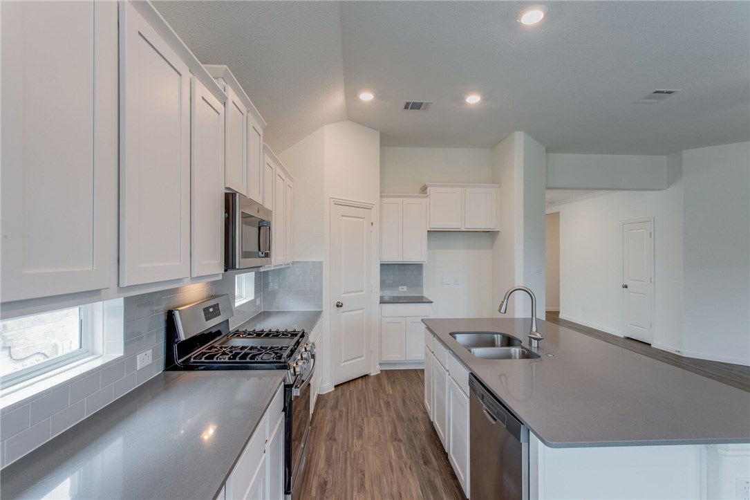 312 Prato Place Georgetown, TX 78628 - Photo 27 of 33 a kitchen with a sink stove top oven and cabinets