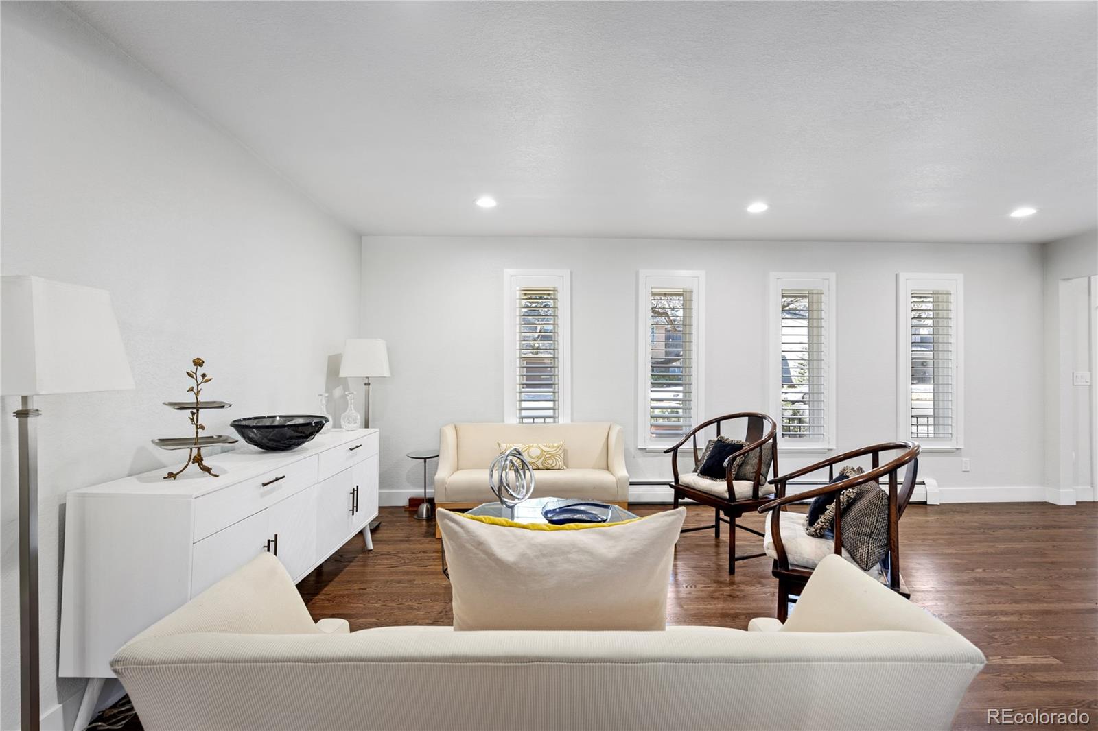 3764 South Niagara Way Denver, CO 80237 - Photo 21 of 50 a living room with couches and kitchen view with wooden floor