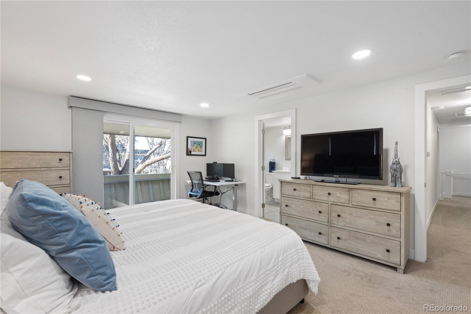 3764 South Niagara Way Denver, CO 80237 - Photo 28 of 50 a bedroom with a bed and a flat screen tv in the kitchen