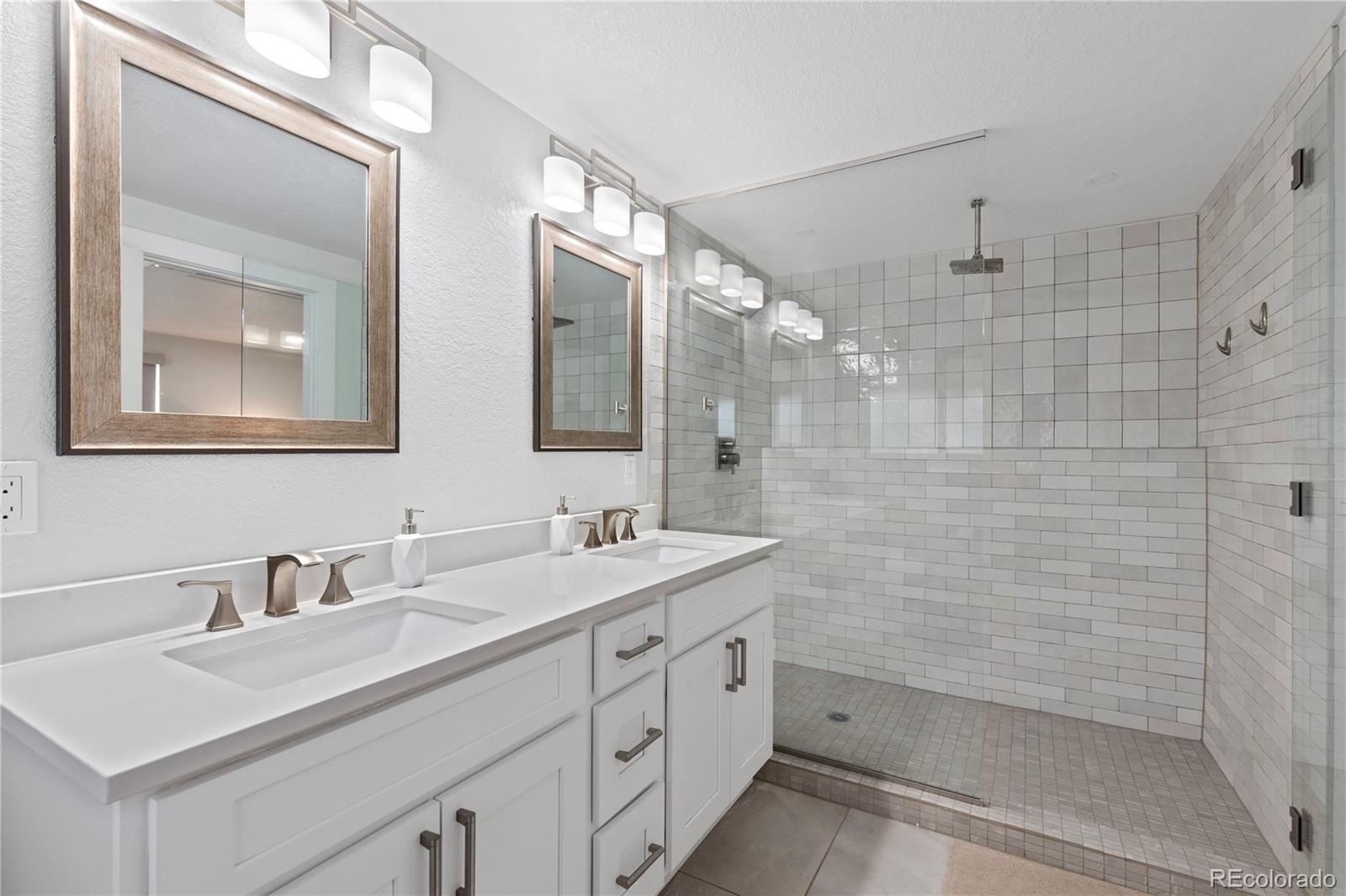 3764 South Niagara Way Denver, CO 80237 - Photo 30 of 50 a bathroom with a double vanity sink mirror and shower