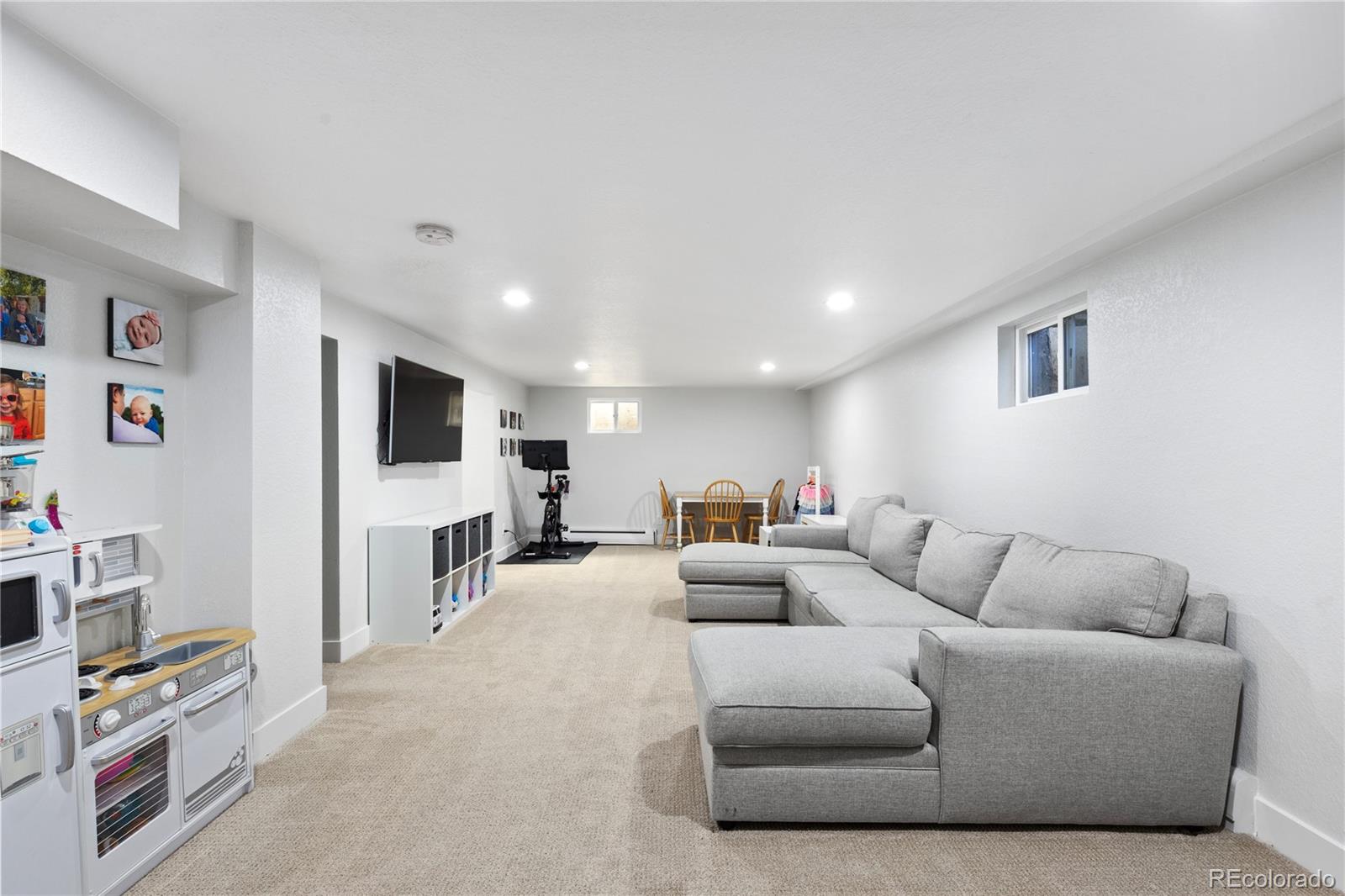 3764 South Niagara Way Denver, CO 80237 - Photo 38 of 50 a living room with furniture and a flat screen tv