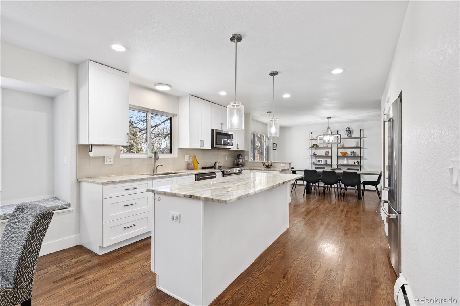3764 South Niagara Way Denver, CO 80237 - Photo 10 of 50 a kitchen with cabinets a sink dishwasher a dining table and chairs with wooden floor
