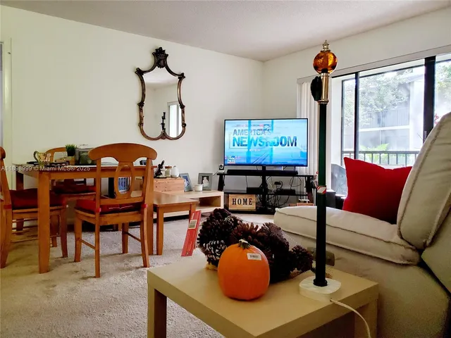 a living room with furniture a window and a flat screen tv