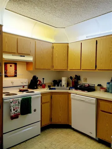 a kitchen with a stove a sink and cabinets