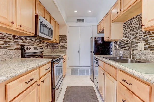 a kitchen with stainless steel appliances granite countertop a sink and a stove