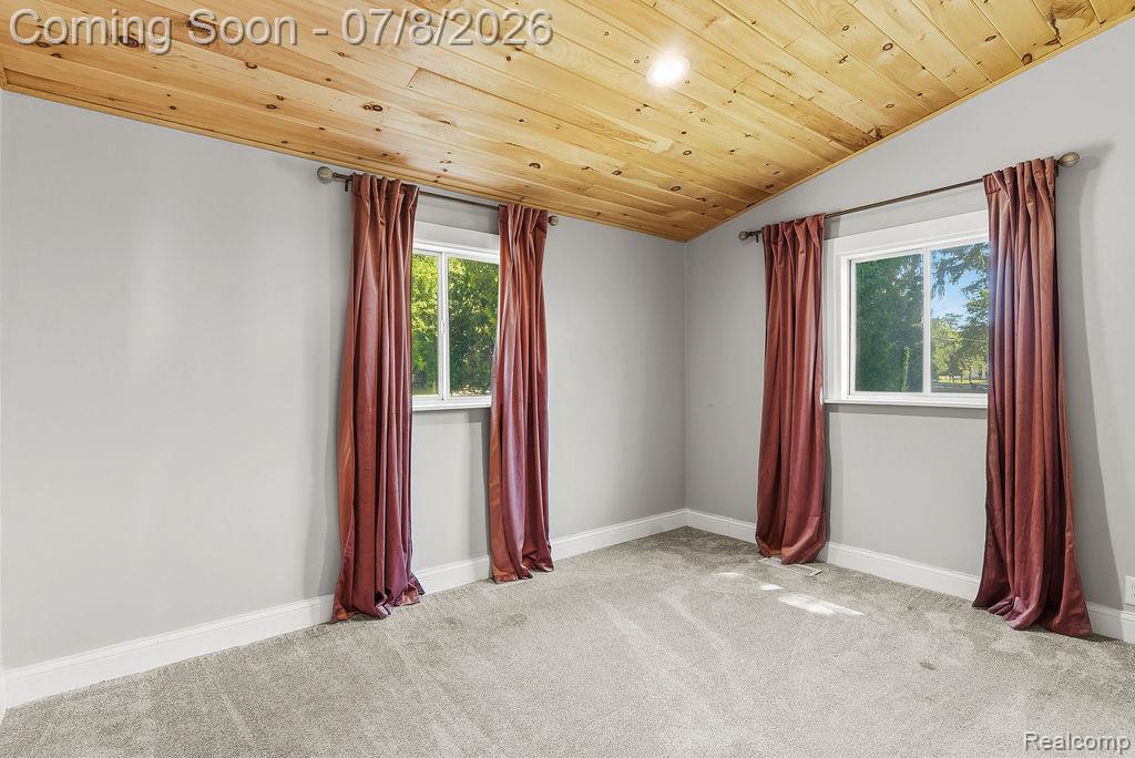 5698 McGrandy Road Bridgeport, MI 48722 - Photo 23 of 26 Room featuring a vaulted wood-finish ceiling, light gray wall paint, and gray carpeting
