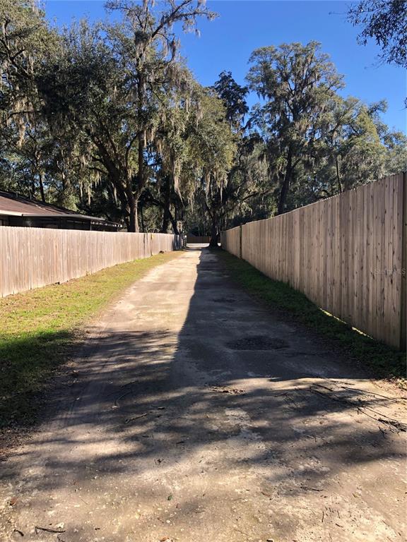 a view of backyard with wooden fence