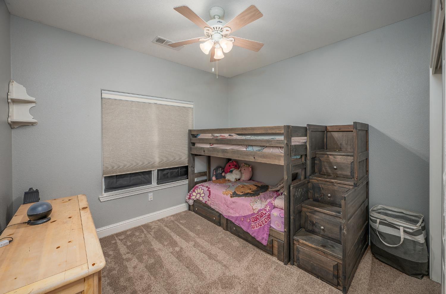4530 Maximus Road Denair, CA 95316 - Photo 21 of 36 a bedroom with a bed and a chandelier