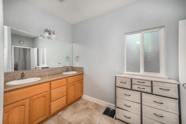a bathroom with a granite countertop sink and mirror