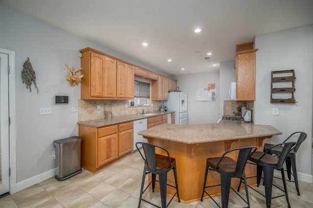 a kitchen with stainless steel appliances granite countertop table chairs sink and stove