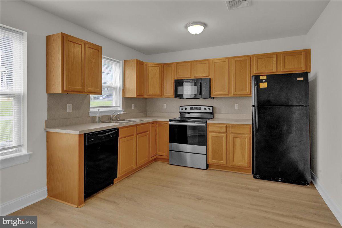 a kitchen with stainless steel appliances a refrigerator stove and microwave