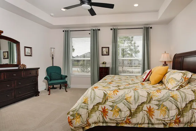 a bedroom with a bed and a dresser next to a window