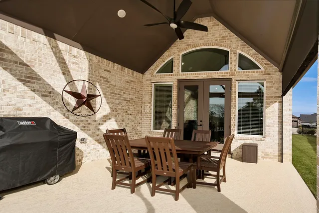 a view of a front door and deck with table and chairs