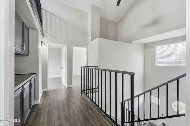 a view of a hallway with wooden floor and staircase