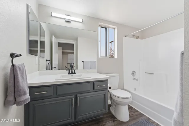 a bathroom with a sink toilet a mirror and shower