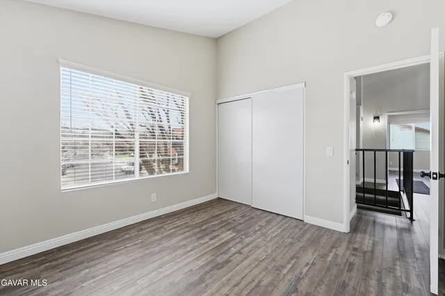a view of wooden floor in an empty room with a window