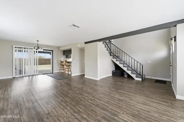 a view of a livingroom with wooden floor and stairs